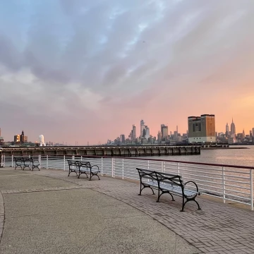 The morning sky blankets Manhattan and its skyscrapers, including the iconic Empire State Building in midtown New York, as seen from the waterfront walkway of Jersey City on a recent winters day.