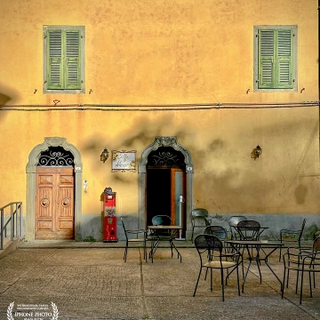 A lazy afternoon stroll in one of the small Tuscany villages. Empty outdoor cafe with casting sun depicts a perfect charming Italy.