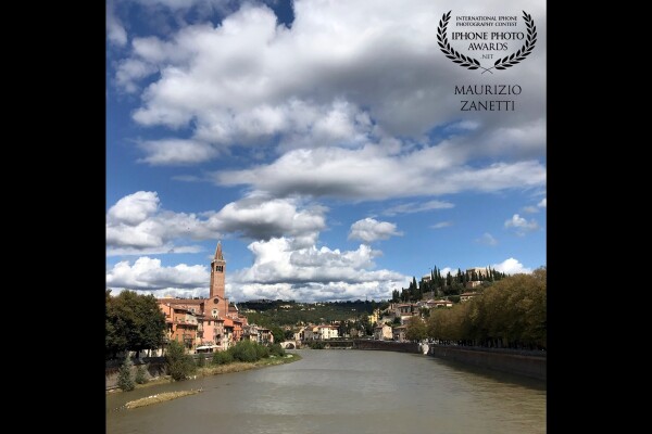 The Adige river gathers the historic center of Verona in a bend. From Ponte Nuovo you have a nice glance: on the left the church of Sant'Anastasia, on the right on the hill surrounded by cypresses Castel San Pietro, in the center, small little, Ponte Pietra. The clouds of a splendid day in late summer are the outline.