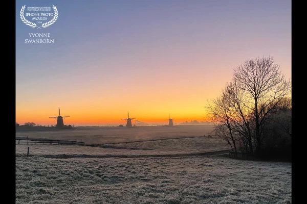 On my way to work I saw this incredible sunrise. I just had to pull over my car to capture this view with its three mills in a little frozen landscape.