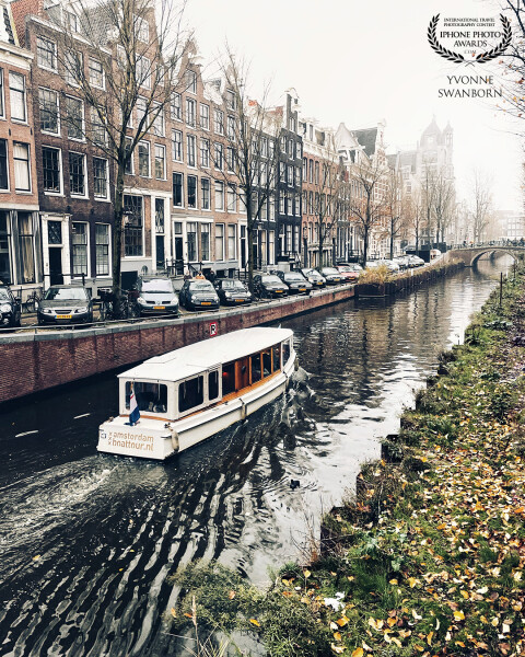 Amsterdam on a very cold, misty day. There are so many canals with beautiful houses and transportation by boats.
