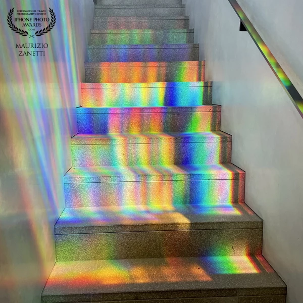 Venice, the internal staircase of an ancient palace. Plays of light from the windows create a rainbow.