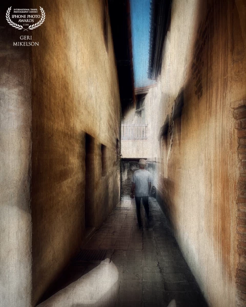 My husband walking down a narrow path at Mission San Juan Capistrano in California. Edited for a more artistic image.