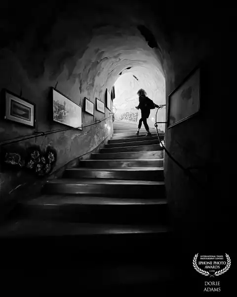 The person on this photo is a friend of mine and I was behind her. I gave her a copy of coloured one and she use it as her profile picture and I transformed it to BNW filter of iPhone and adjust exposure and contrast. This was taken at Wine Cave Museum owned and built by Koutsogiannopoulos family and took 21 year of hard work and perseverance. The cave is 8 meters below ground and 300 meters long. Taken with iPhone 13Pro.