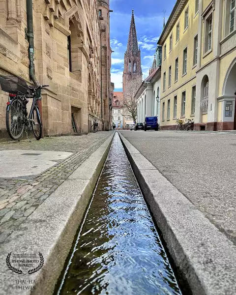 The two most famous landmarks of Freiburg im Breisgau, Black Forest, Germany: water-filled runnels called „Bächle“ which serve as water supply running throughout the city center and not as sewage system. Legend has it that if you step into them accidentally you have to marry a citizen of Freiburg.<br />
<br />
In the background you can see the spire of the Freiburg Minster.