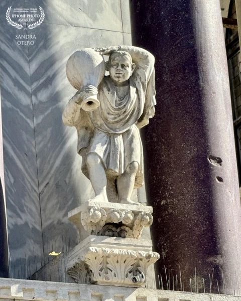 Sculpture of man carrying a wine jug at St Mark’s Basilica, in St Mark’s Square,  Venice. The Basili...