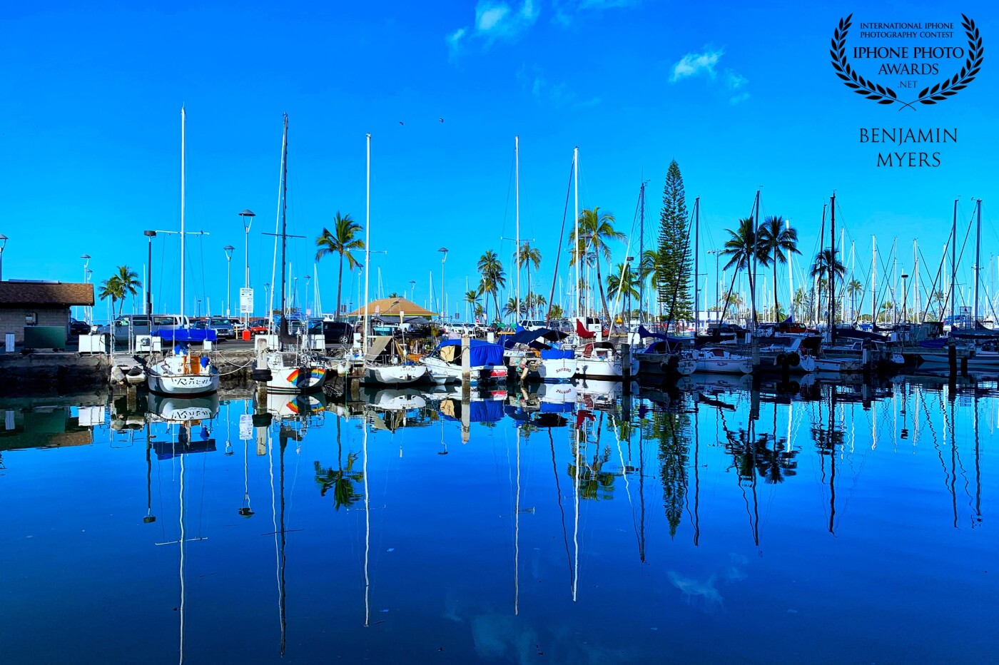 I sometimes leave early for work and watch the waves as they come in. This particular morning I stopped near the Ala Wai Boat Harbor, and the water was calm and glassy. I took this shot and was amazed at how it was almost a mirror reflection. 