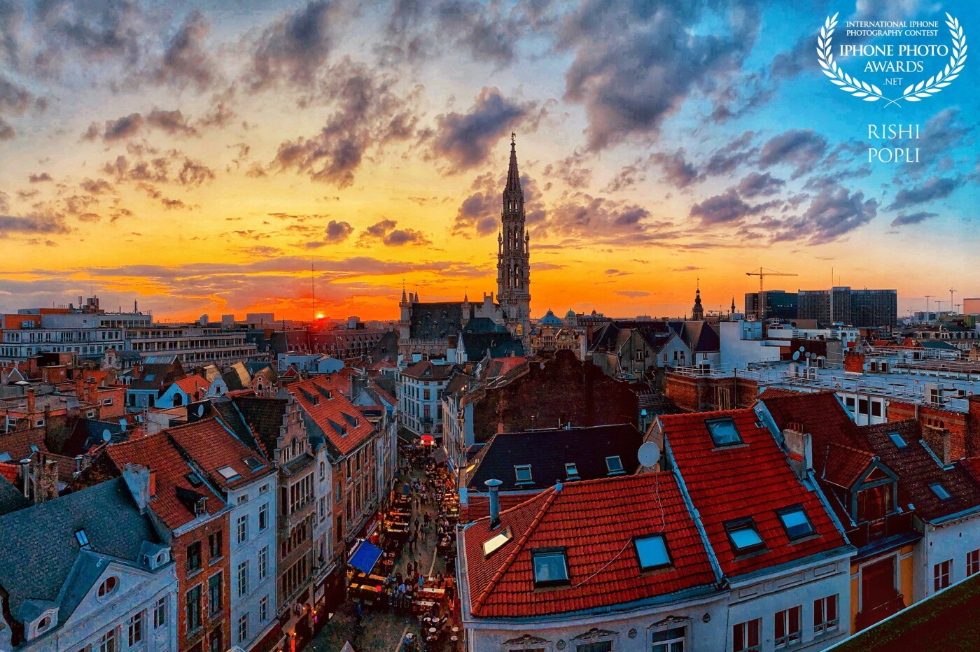 Watching the tip of the Grand Place located in Central Square of Brussels while a beautiful sunset from the rooftop of the Warwick Hotel in Belgium. 