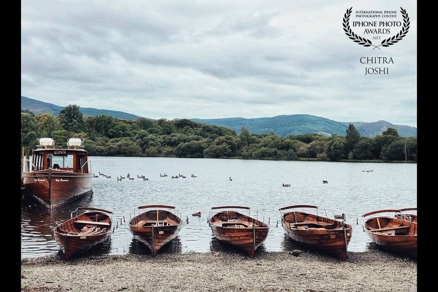 The boats are the characteristic tourist features of Lake District, United Kingdom which has 16 lakes. This view was captured at one of the beautiful lakes named "Derwent Water".