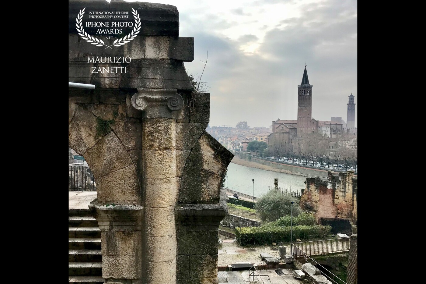The ancient walls of the Roman Theater wet from the rain. In the background "the beautiful Verona" with its Adige river and the church of Sant'Anastasia