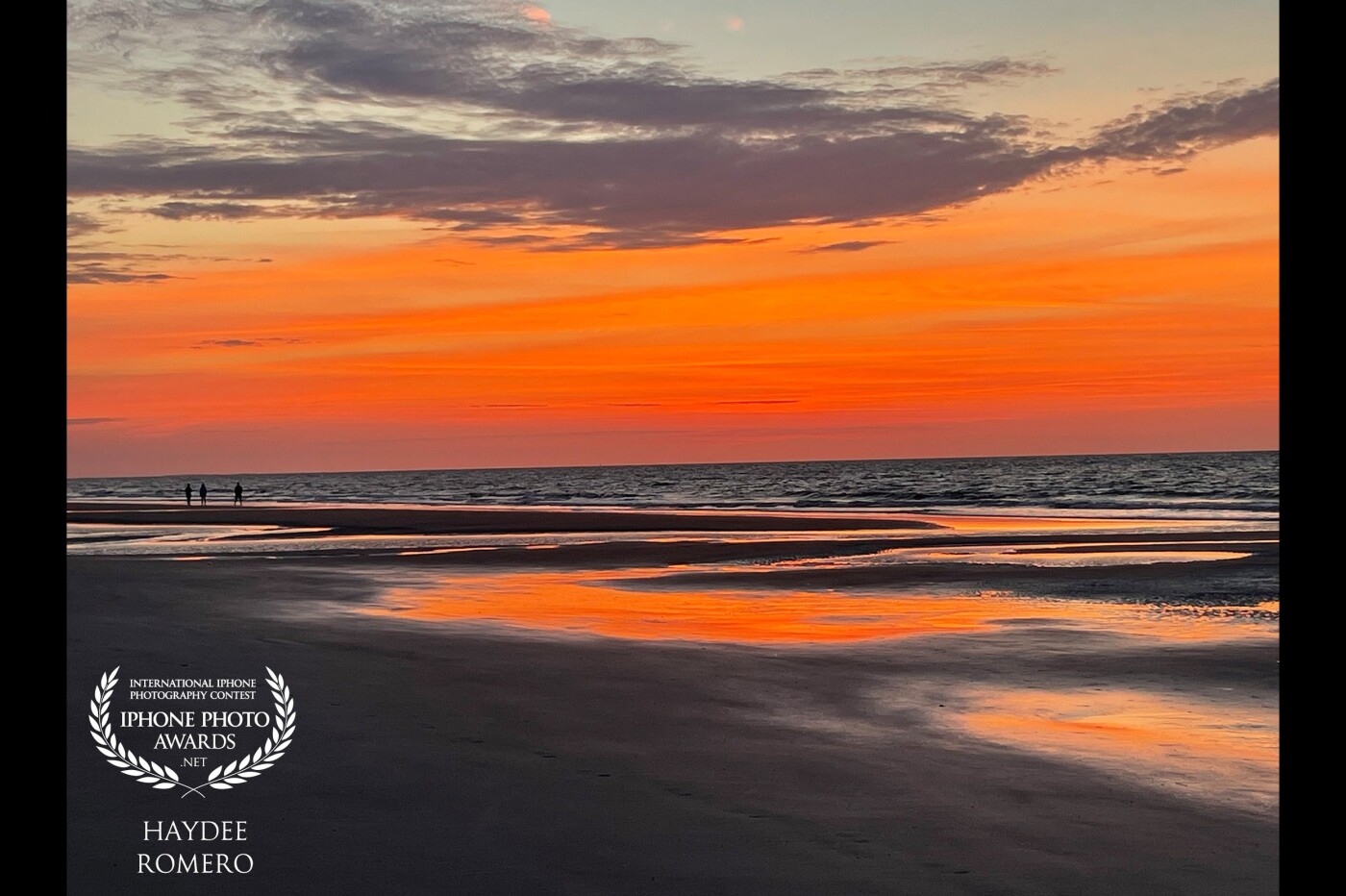 The rising sun casts deep orange colors across the sky and over the wet sand of the beach at Hilton Head in South Carolina, USA, on a recent morning.