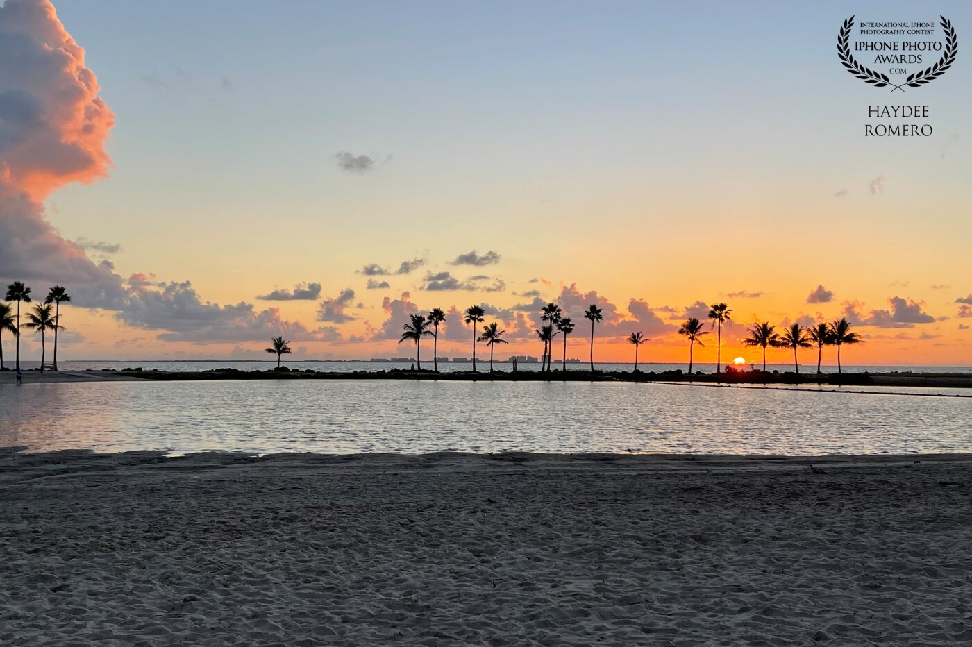 Another beautiful sunrise where  the palm trees rise up against patchy clouds as the sun starts to come out in Matheson Hammock Park in south Miami, Florida.