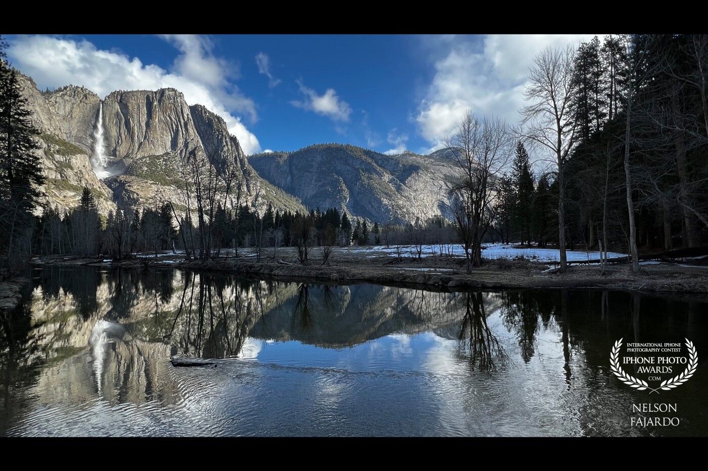 Reflected mountains in a quiet Merced River  with some clouds and trees to give a bit of sense of how grand the mountains really are.