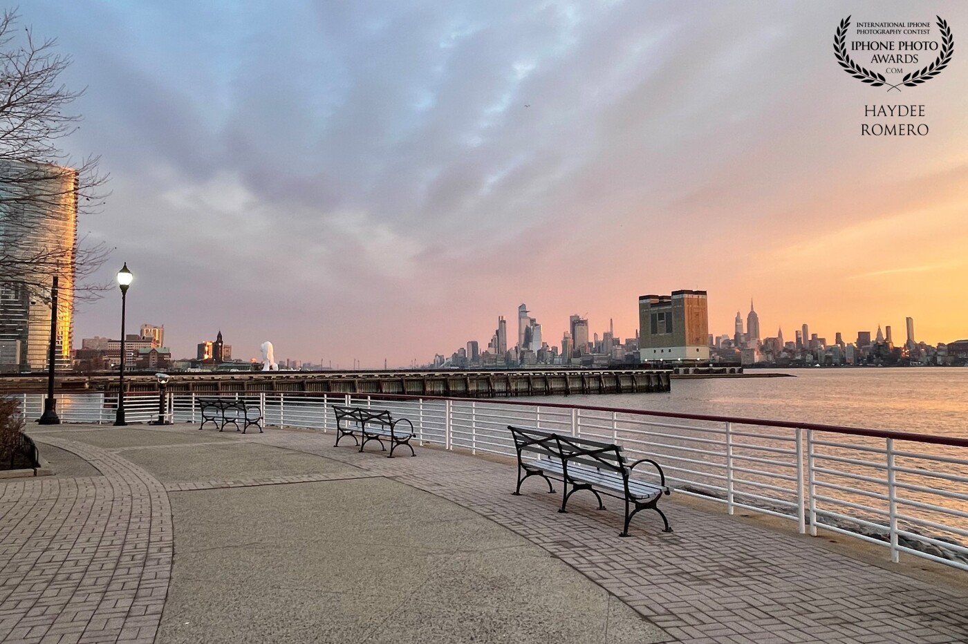 The morning sky blankets Manhattan and its skyscrapers, including the iconic Empire State Building in midtown New York, as seen from the waterfront walkway of Jersey City on a recent winters day.