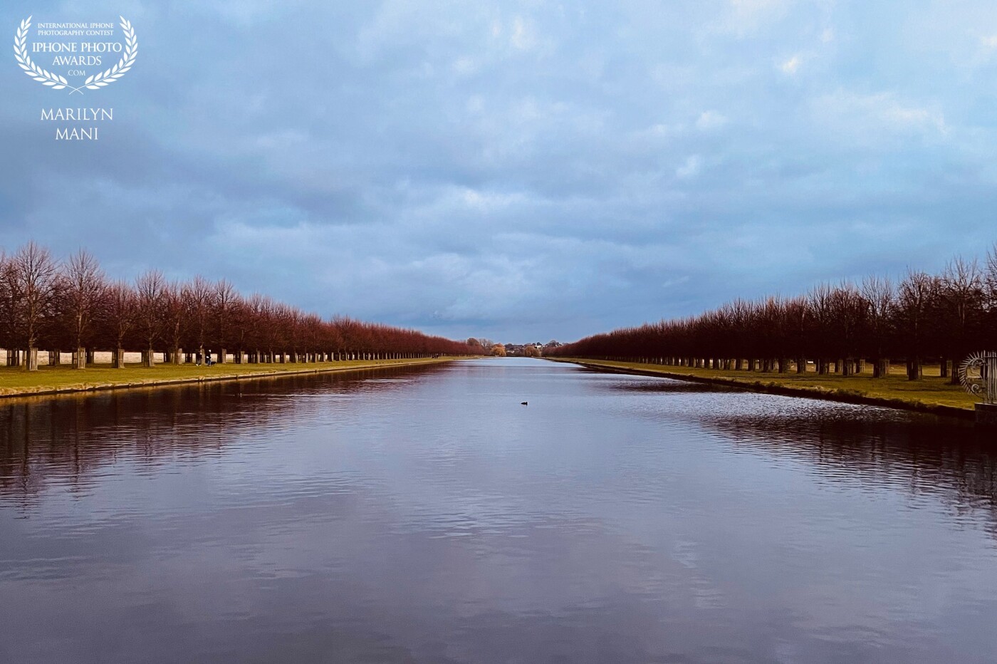 The beautiful and serene Long Water - a garden canal at the Home park, Hampton Court, UK. The symmetry on either sides and the sheer length of the canal makes this scene so beautiful even in the winter months.