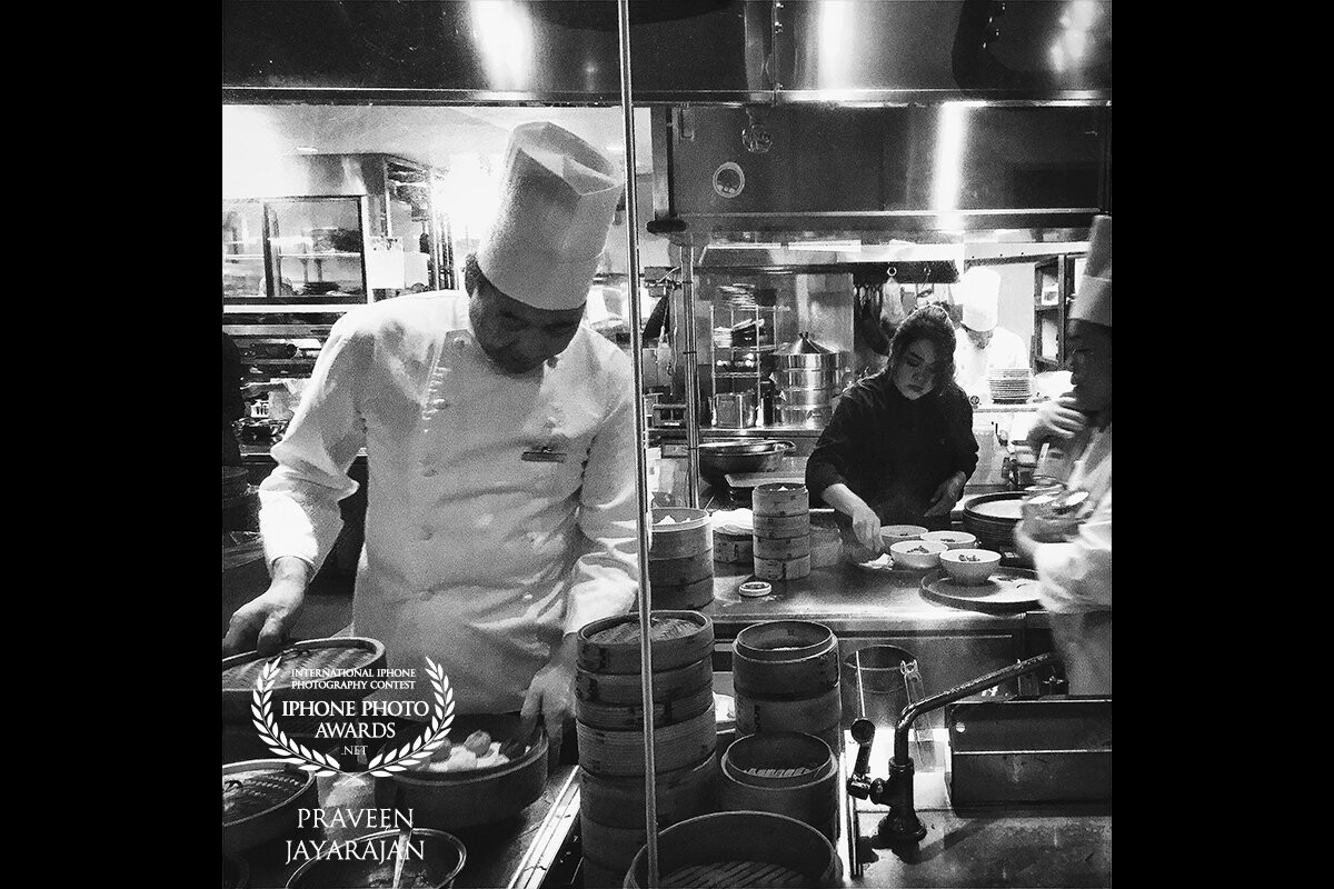 This photo was taken in a busy restaurant in Tokyo.  Dumpling production in full effect with chef master in foreground, and apprentice in the background.