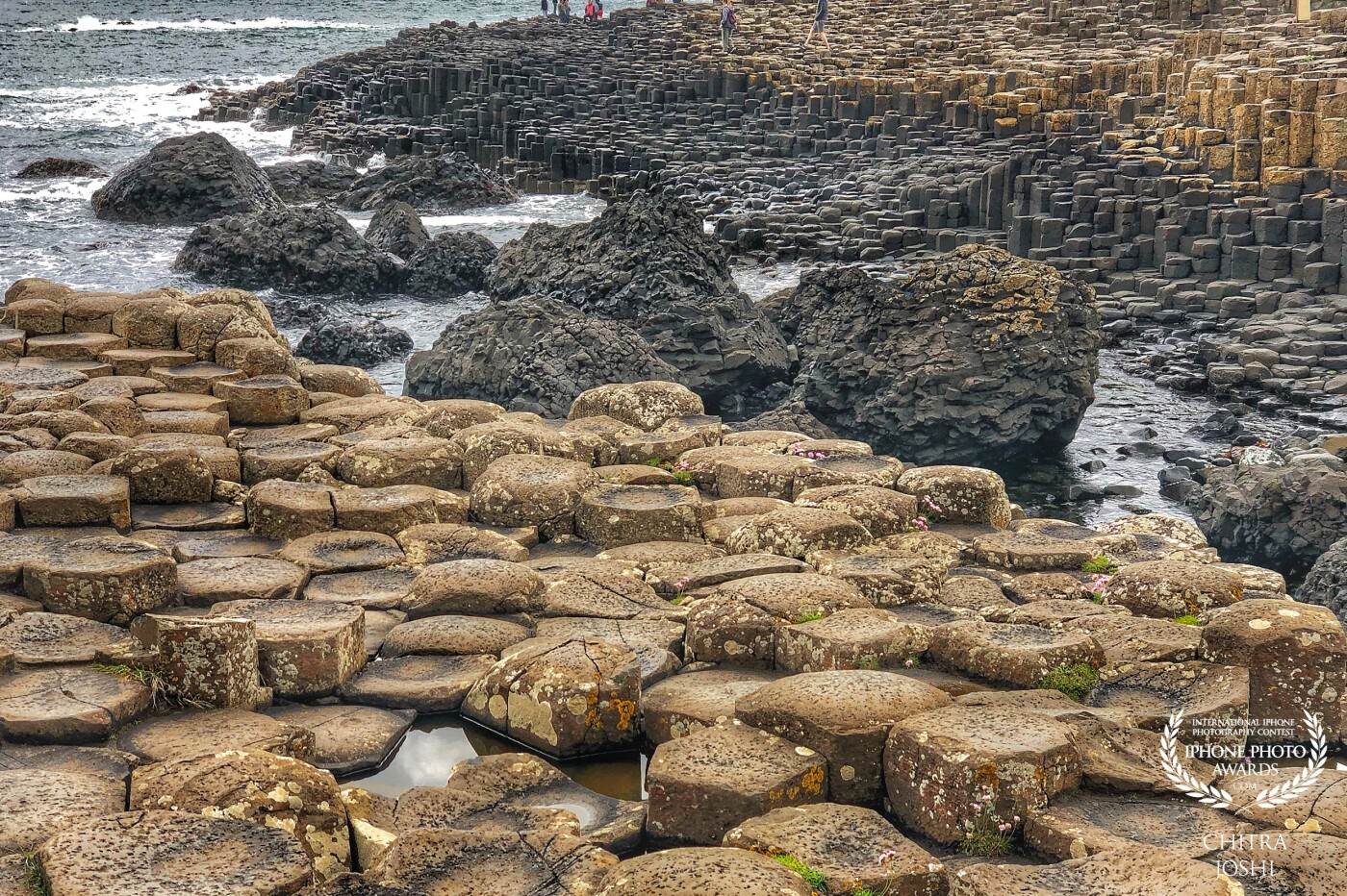 This photo is taken at the famous UNESCO heritage, The Giant's Causeway in Northern Ireland, UK. Look at those perfectly hexagonal stacks of stones. It is believed to be formed due to volcanic eruption.