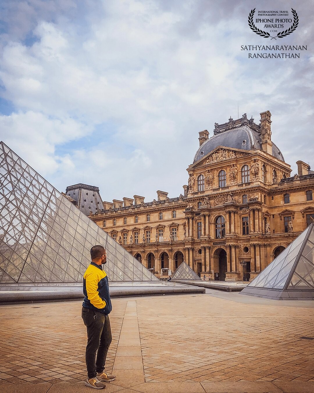 This picture was taken at the Louvre Museum when the guy was watching the mesmerizing architecture in the middle of the Pyramids.