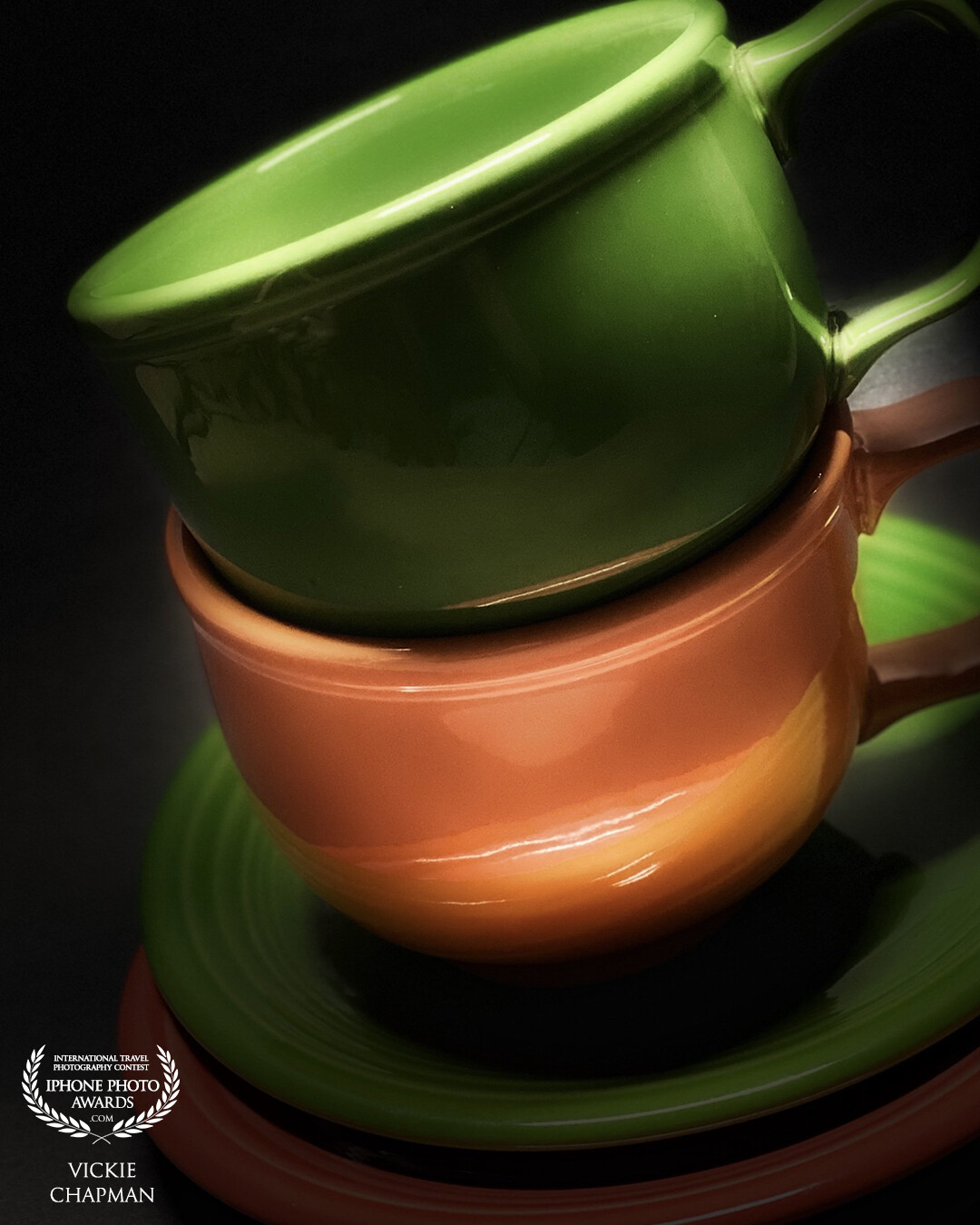 Simple colorful cups and saucers were used with some dramatic lighting to achieve this photo.