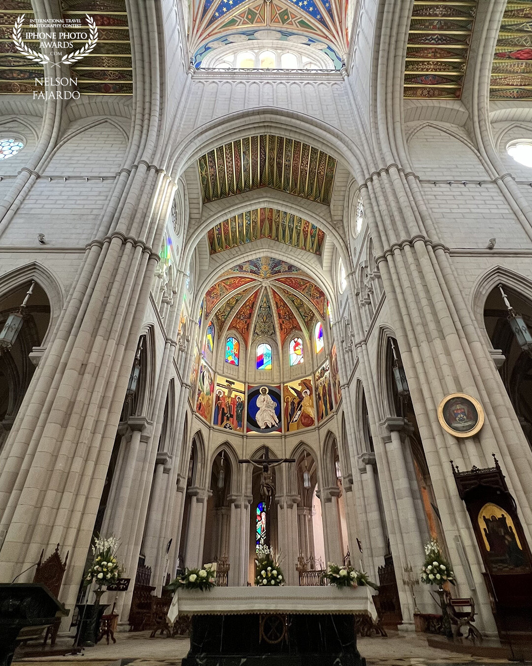 Inside the Almudena Cathedral showcasing the beautiful and colorful ceilings and windows.