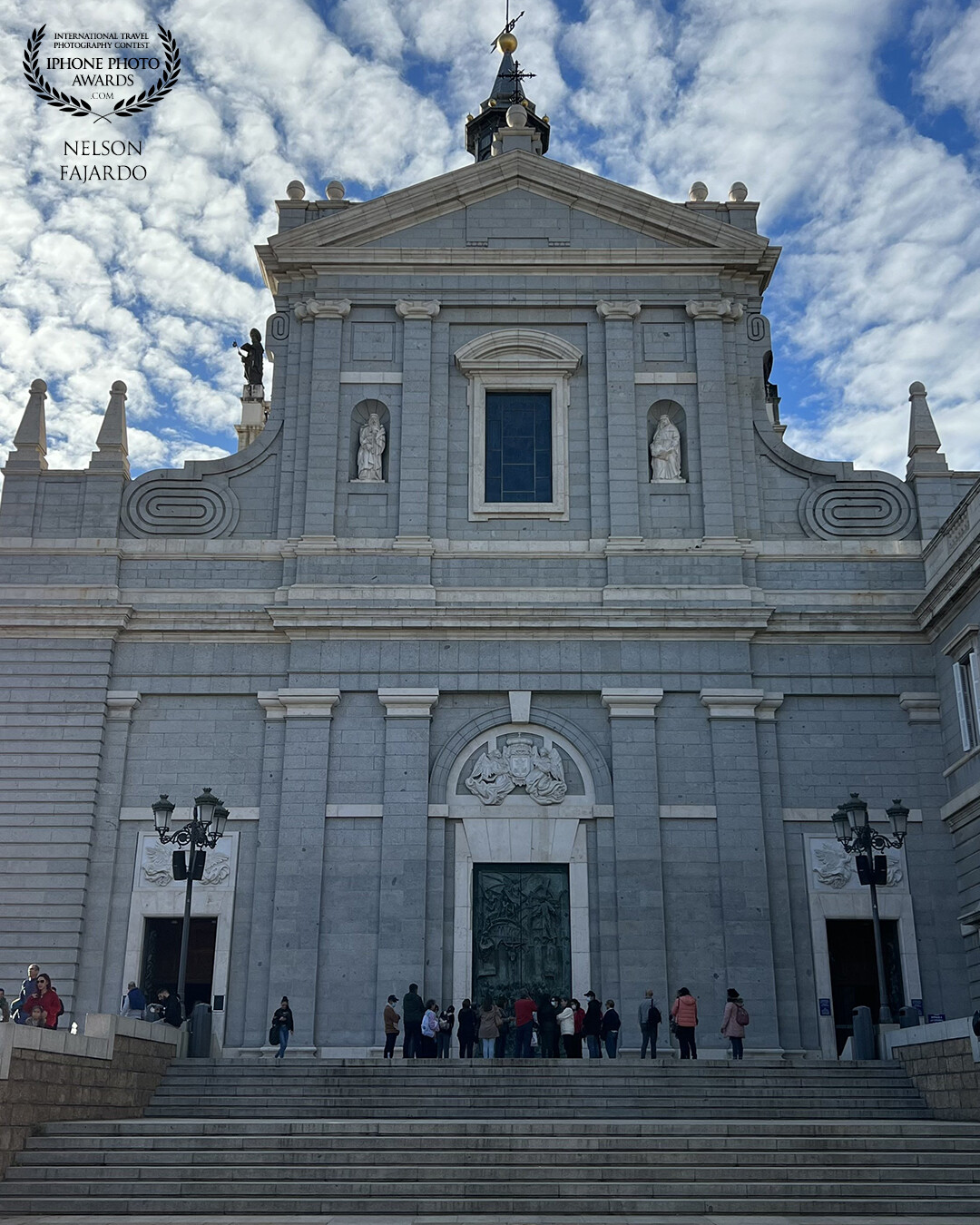 Almudena Cathedral in Madrid, Spain with magnificent copper doorway, visited by many including Pope John Paul II on a sunny afternoon.