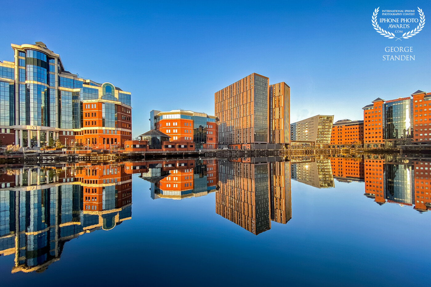 A calm day over Salford Quays, Manchester.  The tall buildings provide a mirror like reflection in the canal.