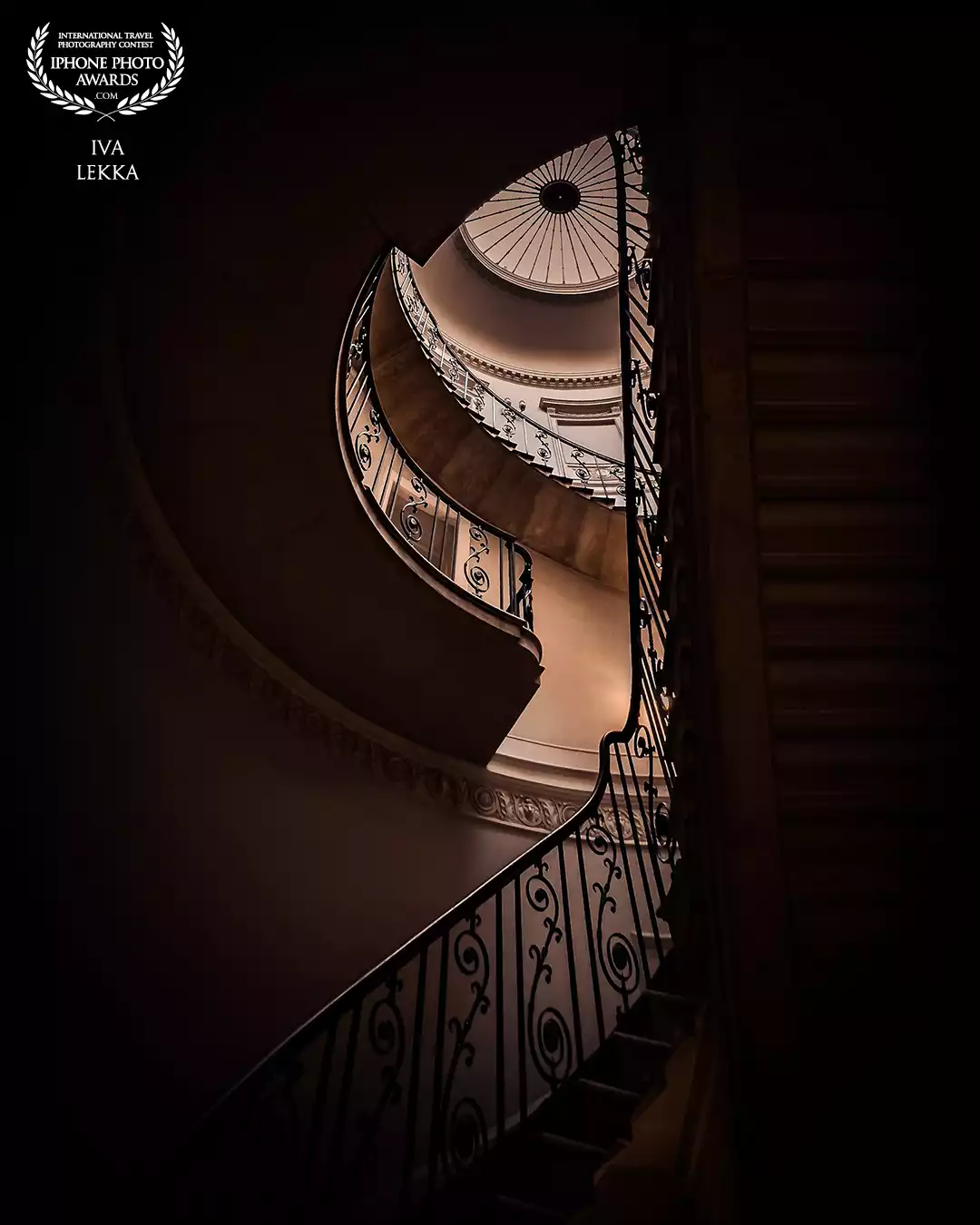 Staircase Pavilion, Budapest.<br />
This spiral staircase sits quietly inside the Staircase Pavilion in Budapest, but from the right angle, it transforms. I chose this position deliberately, framing the shot so the curves formed the shape of an eye. The light at the top became the pupil, giving the structure a quiet sense of awareness. It’s a space of stillness, but from here, it feels like it’s watching back.