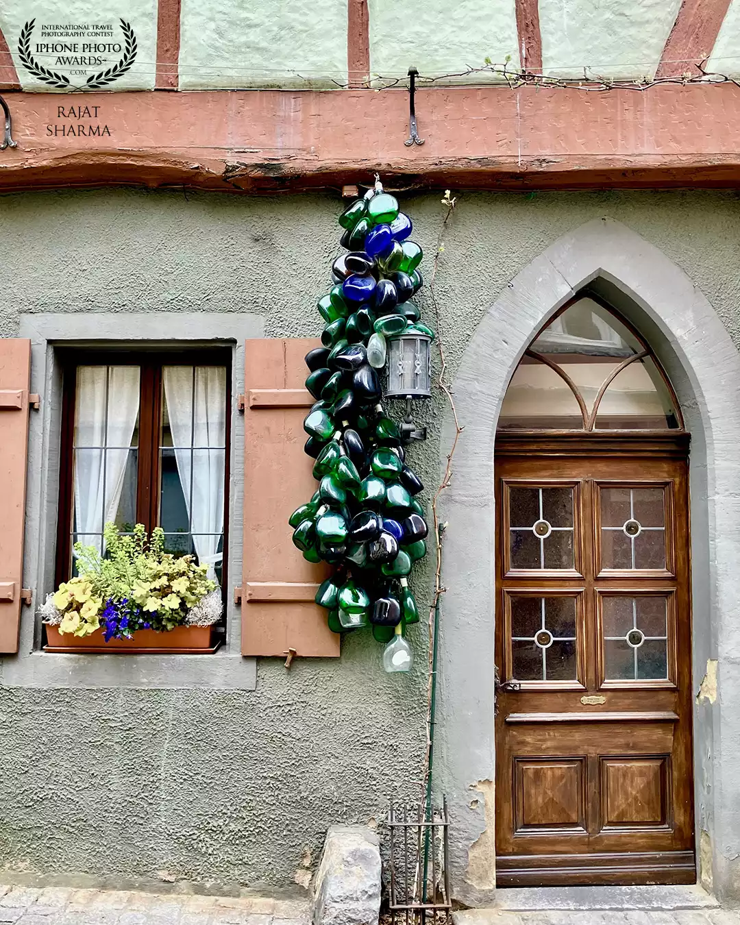 This is a beautiful window I discovered while roaming the streets of Rothenburg ob der Tauber (Germany). The best part about it was the colorful bottles hanging between the door and the window, adding a whimsical charm and a splash of vibrant color to the rustic architecture. Each bottle felt like a tiny vessel of dreams, catching the light and telling silent stories of creativity, nostalgia, and local flair